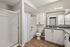 Modern bathroom with sleek cabinetry, spacious shower, and elegant fixtures, highlighted by warm wood flooring and stylish decor.