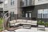 Chic outdoor seating area with modern sectional sofa and hanging chair, perfect for relaxing in a stylish urban setting.