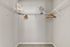 Spacious walk-in closet with elegant white shelving and modern decor, perfect for organizing your wardrobe.