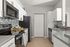 Modern kitchen with sleek stainless steel appliances, elegant white cabinetry, and stylish backsplash for a chic culinary experience.