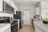 Modern kitchen with sleek stainless steel appliances, pristine white cabinets, and spacious countertops, perfect for culinary creativity.
