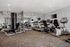 Modern fitness center featuring state-of-the-art exercise equipment including treadmills, stationary bikes, and strength training machines, designed for an invigorating workout experience.