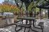 Charming outdoor area with modern grill, shaded seating, and vibrant garden views, perfect for entertaining.