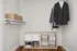 Sleek, organized closet featuring elegant clothing, minimalist storage solutions, and polished wooden floors.