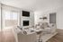 Bright and elegant living room featuring a cozy fireplace, natural light from large sliding glass doors, contemporary furniture, and chic decor.
