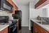 Contemporary kitchen with sleek black appliances, rich wood cabinetry, and elegant countertops.