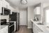Modern kitchen with sleek stainless steel appliances, elegant white cabinetry, and a spacious countertop featuring a stylish coffee maker and sink.