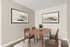 Elegant dining room with wooden table and four chairs, highlighted by modern abstract artwork and a cozy plant centerpiece.