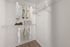 Spacious walk-in closet with ample shelving, hanging clothes, and stylish storage boxes.