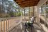 Charming balcony space with a cozy chair and table, overlooking serene wooded views, perfect for relaxing mornings.