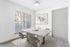 Bright dining area with elegant marble table and modern art, offering a serene window view.