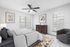 Bright and cozy bedroom featuring a stylish bed with textured pillows, elegant wooden dresser, abstract artwork, and large windows with natural light.