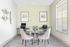 Bright and modern office space with elegant decor, featuring a round table with plush chairs, artistic wall accents, and large windows allowing natural light.