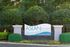 Welcoming entrance sign to Aslan on the River Apartment Homes surrounded by lush greenery and vibrant flowers.