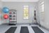 Modern fitness room featuring yoga mats, vibrant medicine balls, and a sturdy punching bag, perfect for a complete workout.