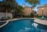 Inviting outdoor pool area with modern seating, surrounded by lush greenery and stylish brick apartments.