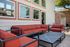 Inviting outdoor patio with stylish red cushioned seating and modern design under a sunny sky.