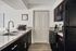 Modern kitchen with sleek black appliances, elegant cabinetry, and a double sink, perfect for culinary enthusiasts.