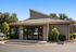 Charming leasing center with modern design, surrounded by lush greenery and welcoming entrance.