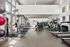 Bright and modern fitness center equipped with state-of-the-art cardio machines and weight training equipment, surrounded by large windows for natural light.