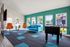 Bright and cheerful lounge featuring modern orange chairs, a sleek blue sofa, and a fun foosball table, perfect for relaxation and entertainment.