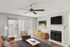 Chic living room with a cozy fireplace, modern ceiling fan, and stylish sofa, perfect for relaxation.
