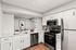 Bright modern kitchen with sleek stainless steel appliances, white cabinetry, and elegant wood flooring.