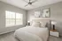 Inviting bedroom with elegant decor, featuring a cozy bed, modern nightstands, and soft natural light through large windows.