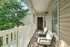 Inviting apartment balcony with cozy seating area, surrounded by lush greenery and natural light.
