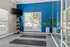 Inviting fitness room with a bright blue accent wall, large windows, yoga mats, and vibrant exercise balls.