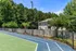 Charming apartment with scenic views overlooking a lush green tennis court and vibrant trees.