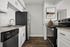 Modern kitchen with sleek stainless steel appliances, elegant granite countertops, and stylish white cabinetry.