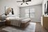 Chic bedroom with modern art, featuring cozy carpet, elegant bed, and large window for natural light.