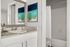 Chic bathroom with elegant granite countertop, stylish abstract art, and modern fixtures.