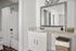 Modern bathroom with elegant granite countertop, large mirror, and classic white fixtures.