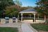 Charming outdoor pavilion with built-in grills, nestled in a lush green setting ideal for gatherings and relaxation.