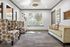 Cozy lounge area with stylish patterned armchairs and a plush sofa, large window view of greenery, and elegant decor accents for a welcoming atmosphere.
