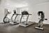 Contemporary fitness center with two treadmills and an exercise bike, set in a bright, naturally lit space with large windows.