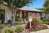 Charming apartment entrance with lush landscaping and future resident parking, perfect for welcoming new tenants.