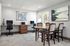 Modern home office with granite countertops, elegant table, and natural light from large windows.