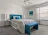 Inviting bedroom with elegant blue accents, large window, and modern furnishings, offering a tranquil retreat.