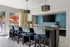 Chic and modern kitchen area featuring bold pendant lighting, colorful upholstered bar stools, and a sleek bar counter with vibrant d&eacute;cor.