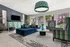 Chic apartment lounge with plush blue seating, modern decor, and large windows overlooking a serene outdoor view.