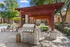 Charming outdoor patio with stylish pergola, modern grill, and vibrant green seating, perfect for entertaining in a serene apartment complex setting.