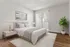 Bright and inviting bedroom with a soft grey color palette, featuring a cozy bed, elegant bedside table, stylish artwork, and a lush green plant by the window with vertical blinds.