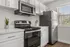 Modern kitchen with sleek stainless steel appliances, white cabinetry, and bright natural lighting.