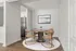 Modern dining area with elegant round table, four stylish chairs, and chic wall art in a bright open-concept space.