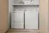 Modern laundry nook with sleek washer and dryer, featuring convenient shelving for storage and organization.