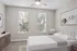 Bright and modern bedroom with elegant decor, featuring large windows, a plush bed, and stylish furnishings.