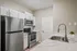 Modern kitchen with sleek stainless steel appliances, elegant white cabinetry, and a stylish marble countertop with a contemporary faucet.